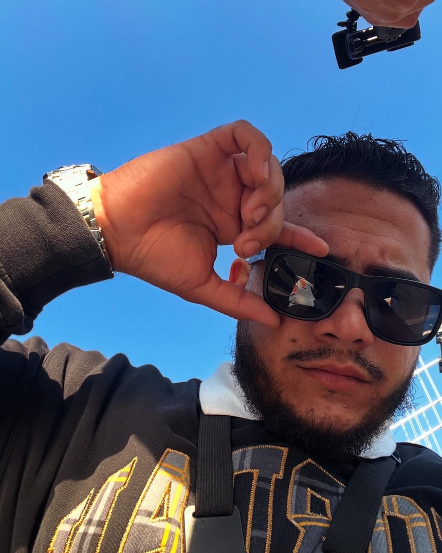 Selfie en contrapicado con gafas de sol bajo un cielo azul